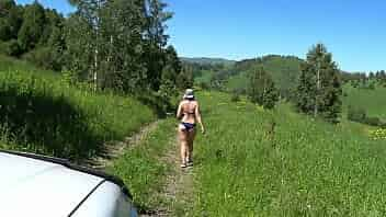 A mature blonde with a gorgeous ass in a swimsuit walks along the road and drives car drivers crazy. Voyeur in a public place outdoors peeping. video